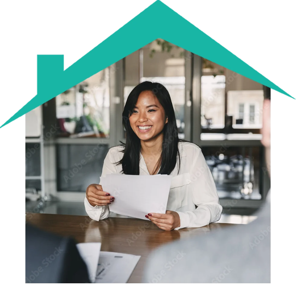 Smiling woman reviewing documents in an office.