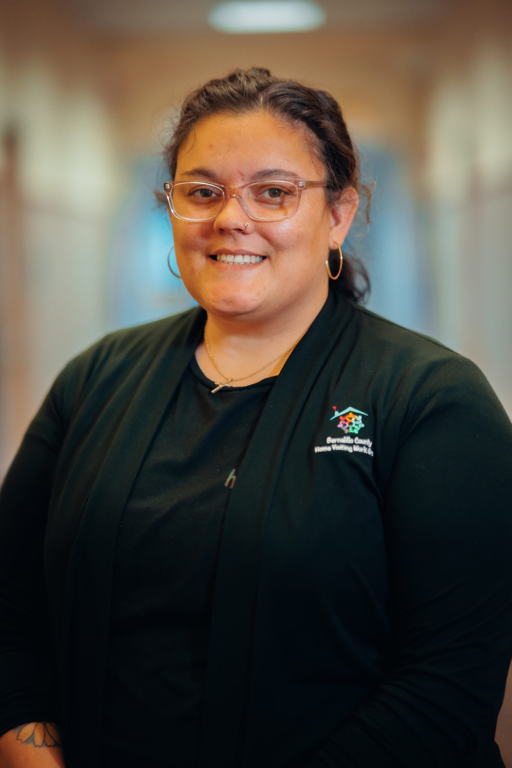 Smiling woman wearing glasses and a black shirt.