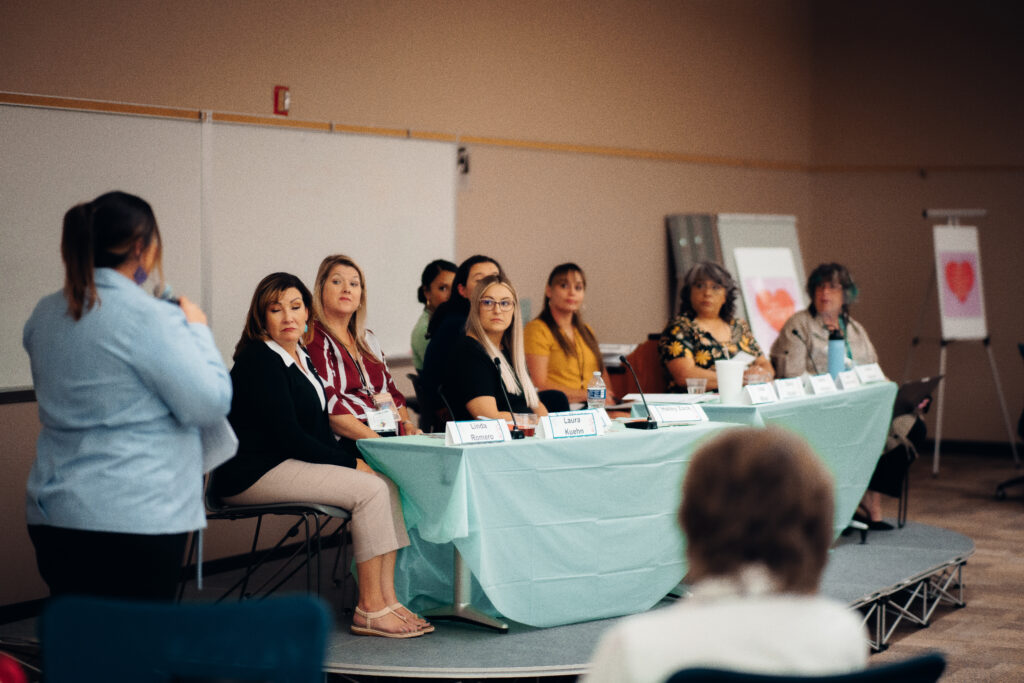 Women on a panel discussion at a conference.