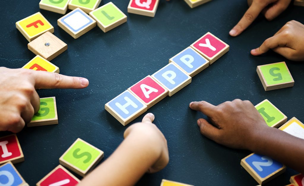 Children playing with colorful letter blocks.