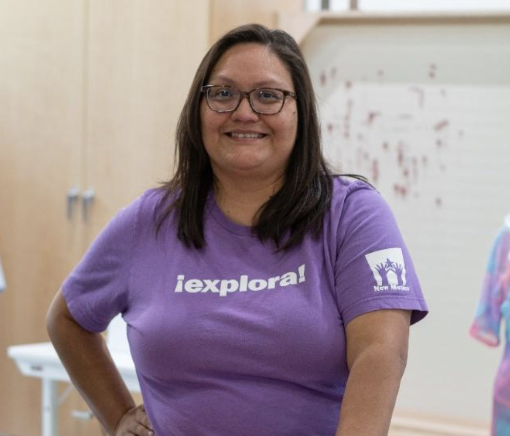 Person smiling in a purple "iexplora!" shirt.