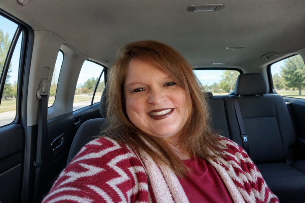 Woman smiling inside a car.